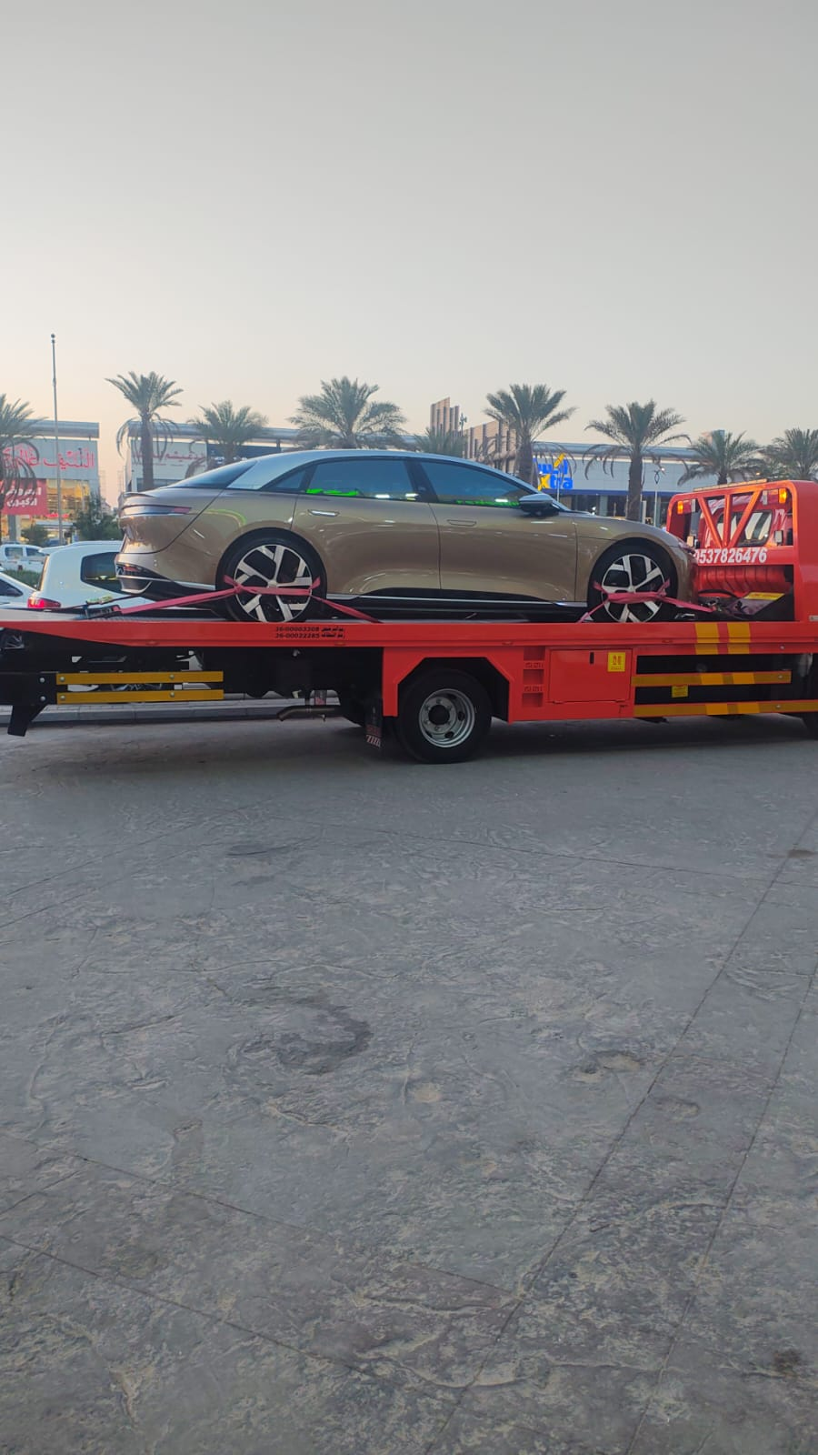 سطحة تنقل سيارة لوسيد إير ذهبية فاخرة في الرياض